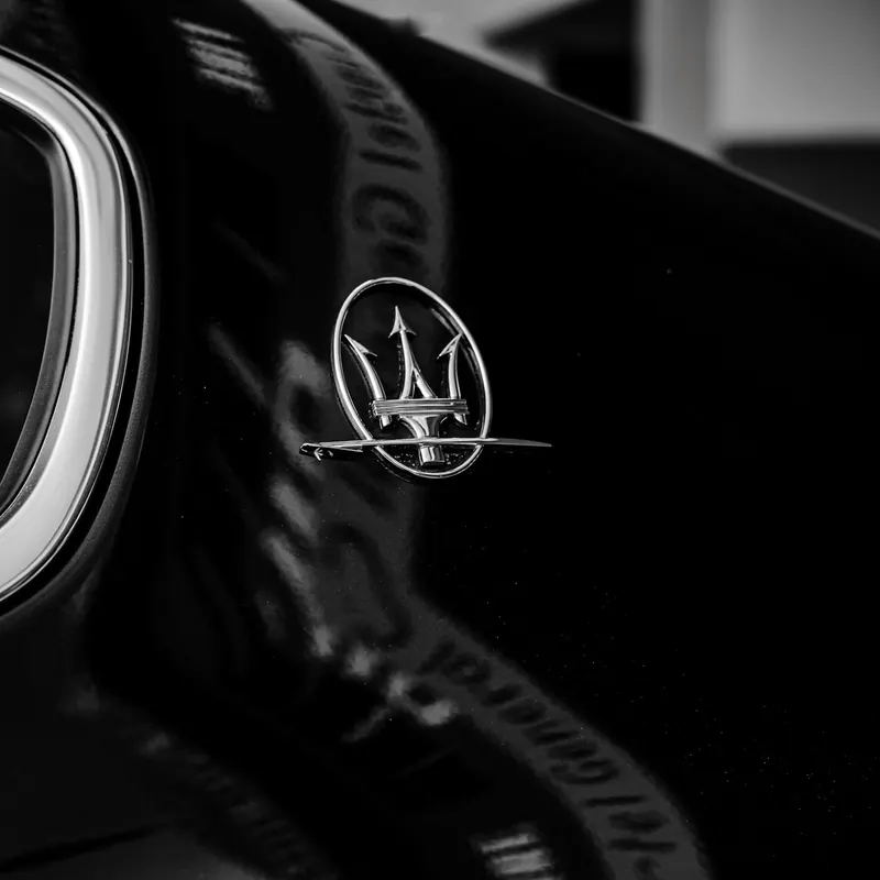 Эмблема Maserati на чёрном автомобиле