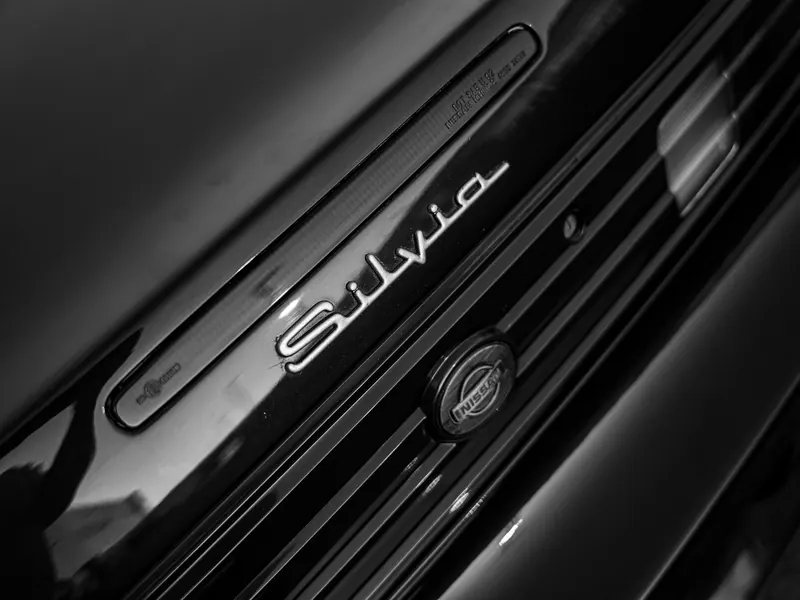 Шильдик и эмблема Nissan Silvia на чёрном автомобиле